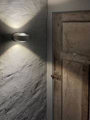 LED Wandleuchte an einer Wand montiert, die ein warmes Licht nach oben und unten abstrahlt, seitliche Perspektive