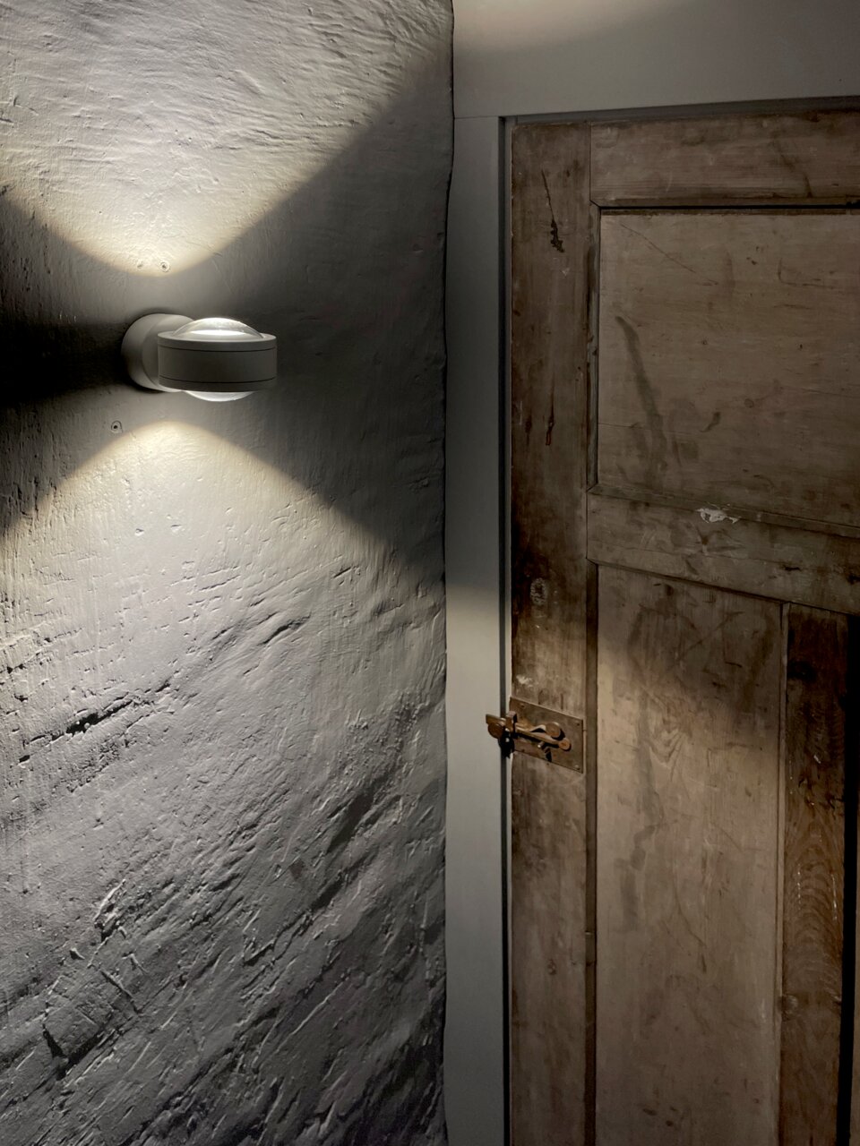 LED Wandleuchte an einer Wand montiert, die ein warmes Licht nach oben und unten abstrahlt, seitliche Perspektive