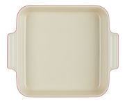 Vogelperspektive auf eine quadratische, cremefarbene Auflaufform mit roten Rändern und seitlichen Griffen.