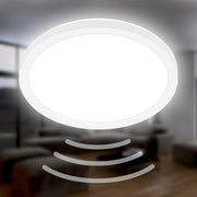 Runde LED-Deckenleuchte mit Bewegungssensor, von unten betrachtet, in einem modernen Wohnraum.