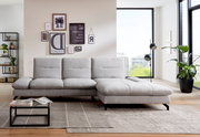 Graues Ecksofa in modernem Wohnzimmer, von vorne betrachtet, mit dekorativen Kissen und einem Couchtisch auf einem Teppich.