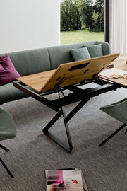 Moderner Esstisch mit verstellbarer Tischplatte in einem stilvollen Wohnzimmer, seitliche Perspektive.