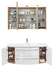 Badezimmerkombination bestehend aus einem Spiegelschrank mit offenen Türen, gefüllt mit Pflegeprodukten, und einem Waschtisch mit geöffneten Schranktüren, gefüllt mit Handtüchern und Pflegeartikeln. Frontalansicht.