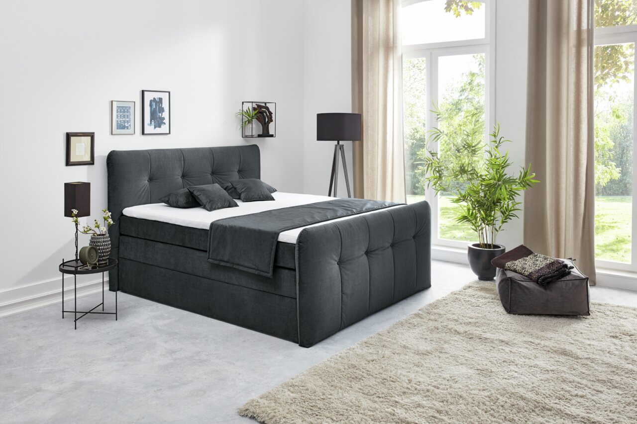 Z2 Boxspringbett COSIMA Boxspringbett in einem modernen Schlafzimmer, seitliche Perspektive, mit großen Fenstern und stilvoller Dekoration.