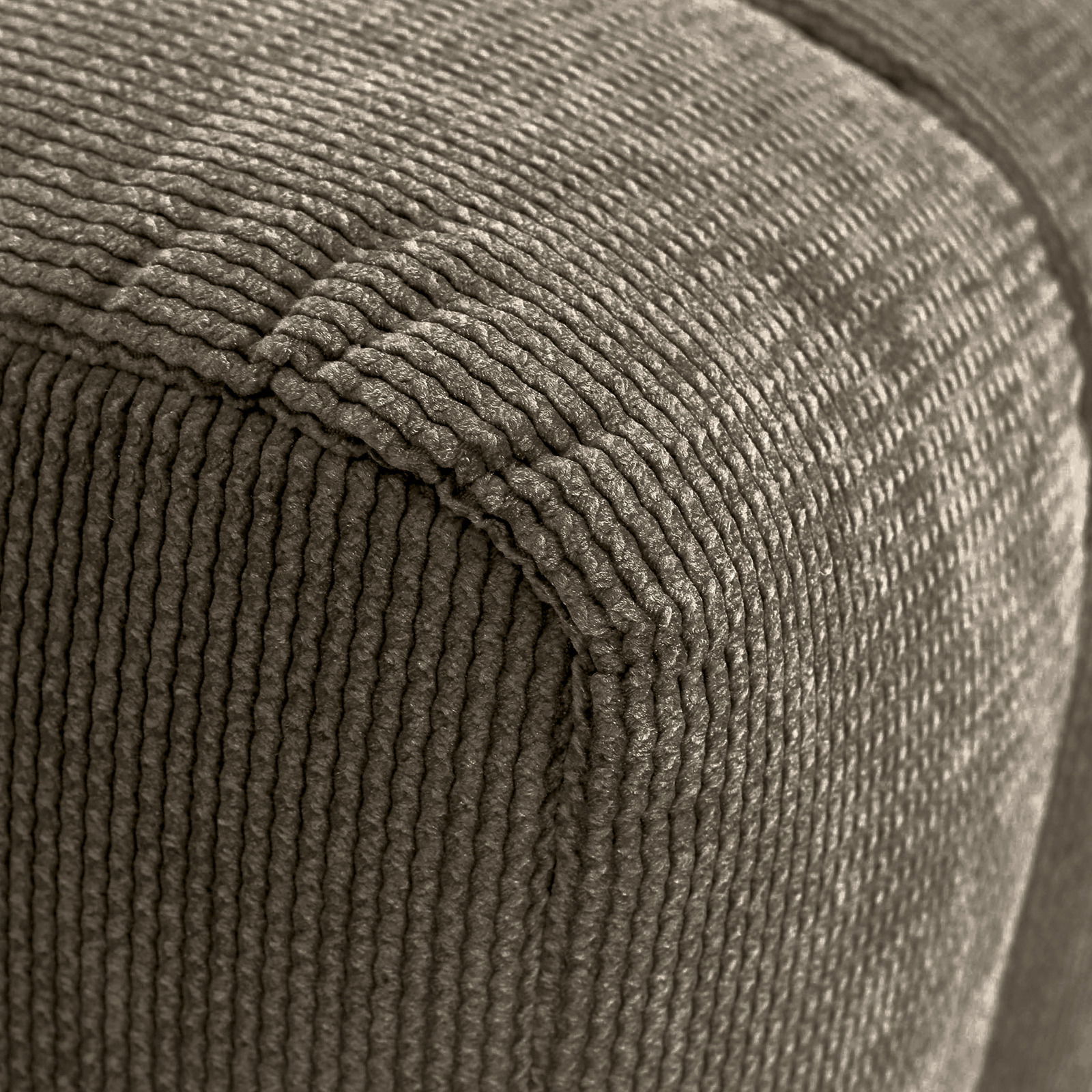 Nahaufnahme eines Hockers mit geripptem Stoffbezug, Perspektive von der Ecke.