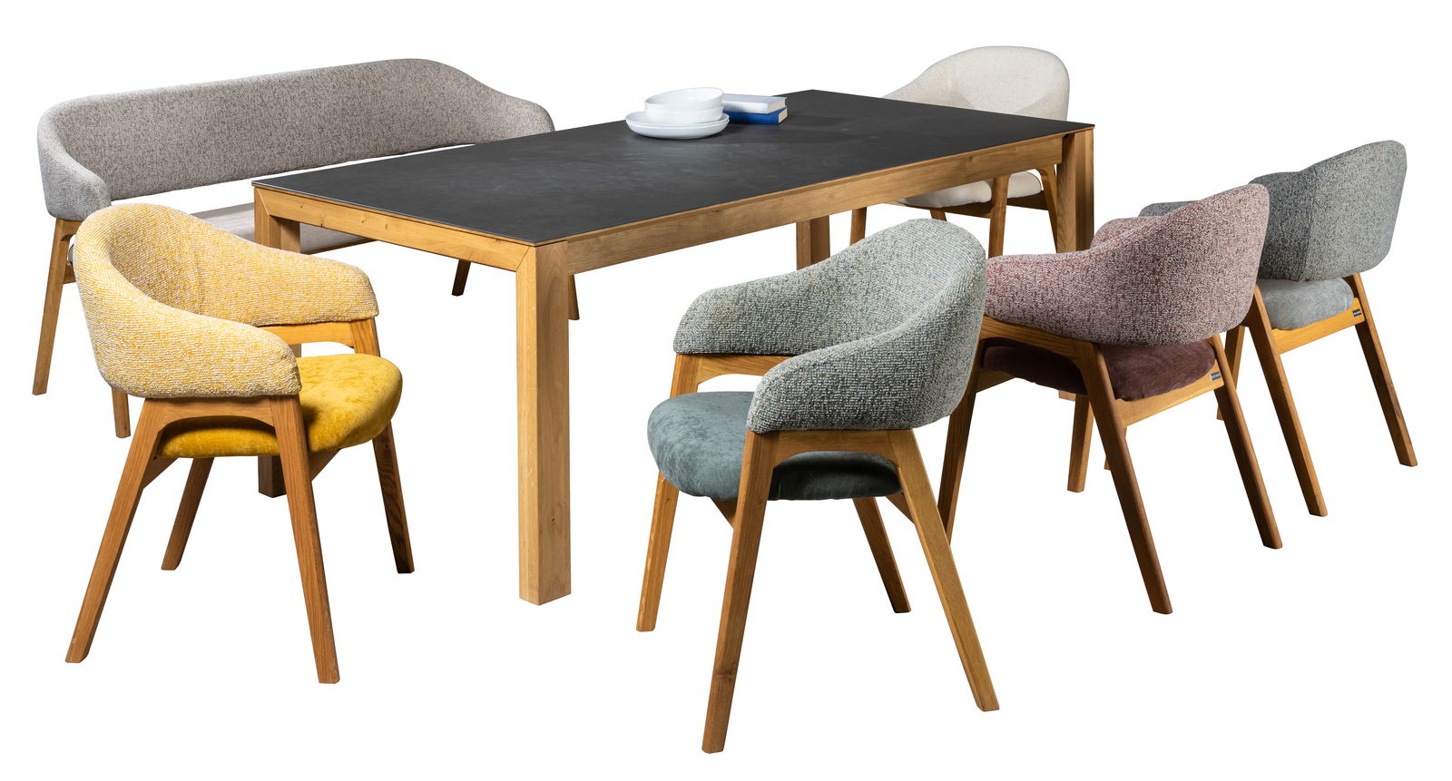 Esszimmer mit einem Tisch aus Holz und sechs Armlehnstühlen in verschiedenen Farben, seitliche Perspektive