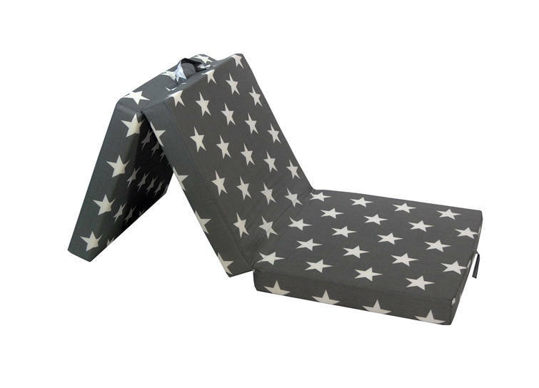 Faltmatratze mit Sternenmuster, teilweise aufgeklappt, seitliche Perspektive
