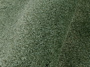Nahaufnahme eines grünen Uni-Teppichs mit weicher Textur, seitliche Perspektive