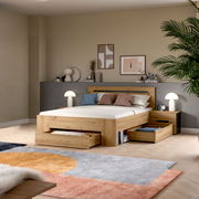 Modernes Holzbett mit Stauraum-Schubladen und passendem Nachttisch im Schlafzimmer, schräg von vorn aus leicht erhöhter Perspektive fotografiert