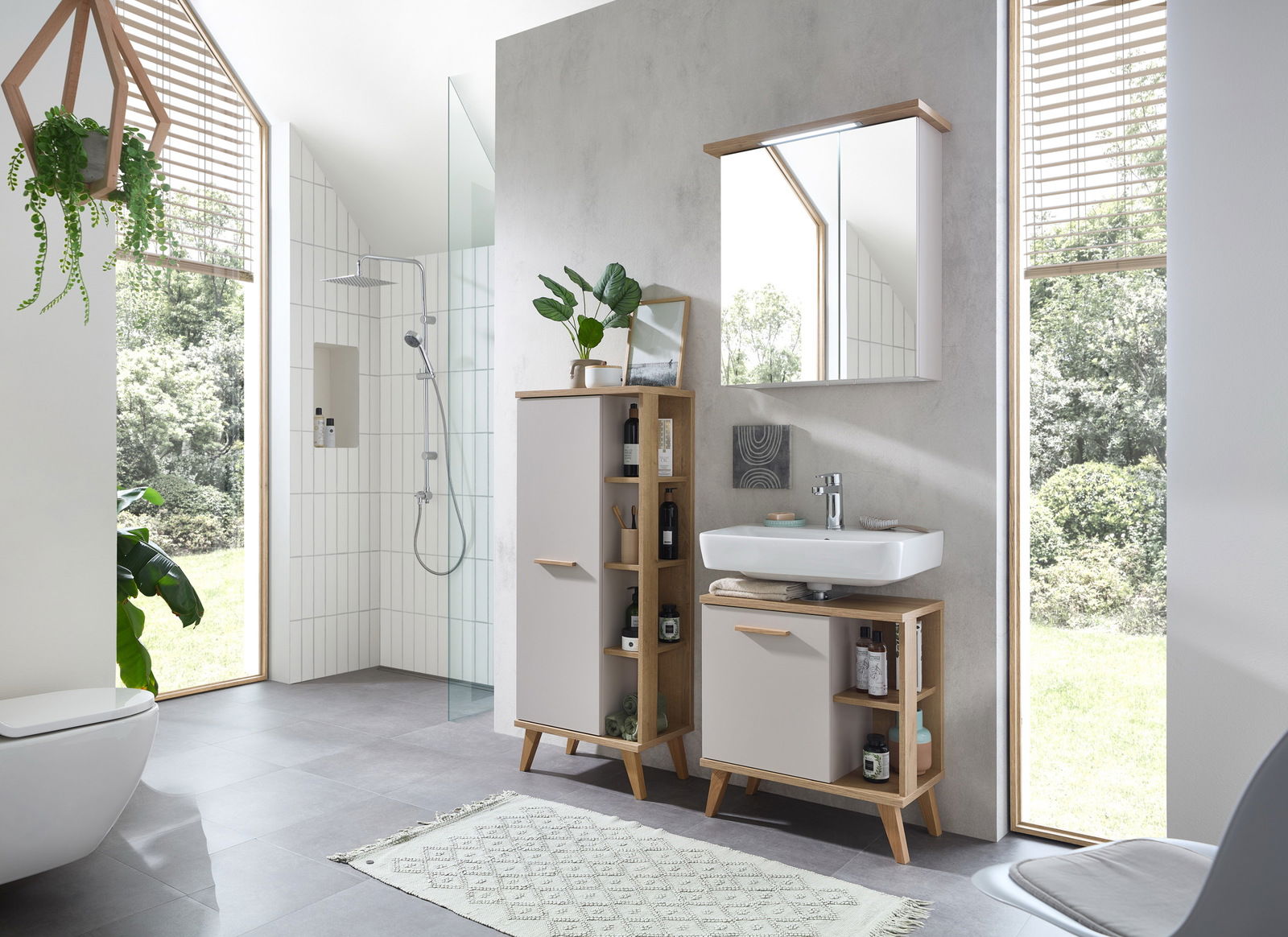 Moderner Midischrank im Badezimmer, frontal fotografiert, mit Holz- und weißen Elementen, umgeben von Pflanzen und einem Waschbecken.