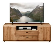 Frontansicht eines TV-Lowboards aus hellem Massivholz mit zwei Schranktüren und zwei Schubladen sowie offenem Fach, darauf ein großer Flachbildfernseher