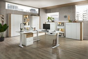 Moderner Büroraum mit weißem Eckschreibtisch, Aktenschränken und Regalen, aus der Perspektive des Raumeingangs fotografiert.
