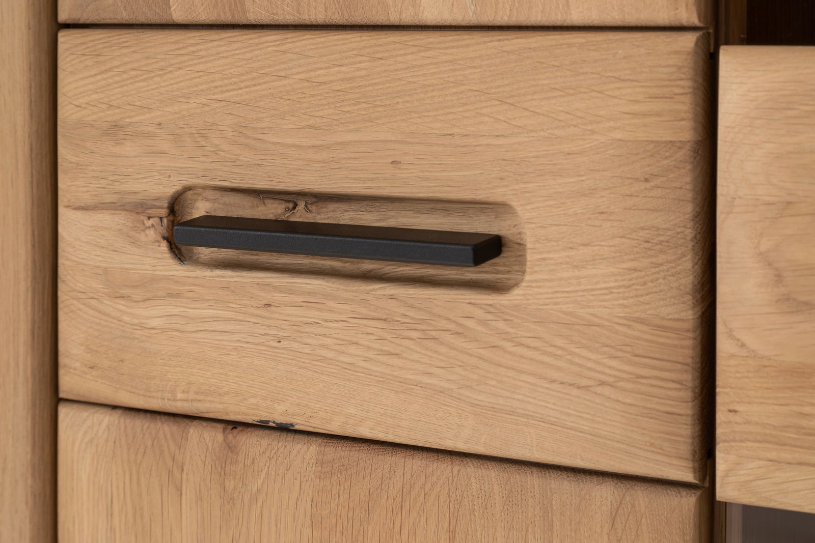 Nahaufnahme eines Holzschranks mit schwarzem Griff, seitliche Perspektive