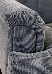 Nahaufnahme einer grauen, strukturierten Polsterung eines Sofas, Perspektive von der Armlehne.