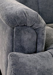 Nahaufnahme einer grauen, strukturierten Polsterung eines Sofas, Perspektive von der Armlehne.