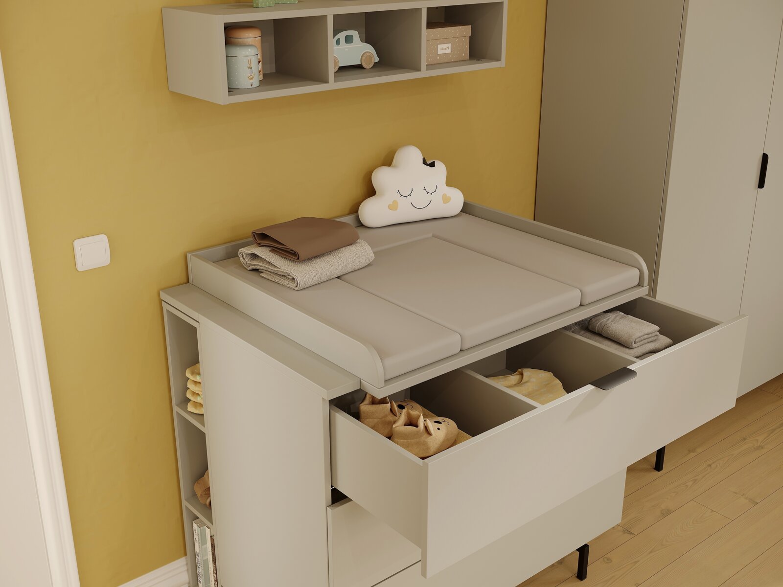 Wickelaufsatz in einem Kinderzimmer, seitliche Perspektive, mit offenen Schubladen und Regalen, dekoriert mit einem Wolkenkissen und Babyartikeln.