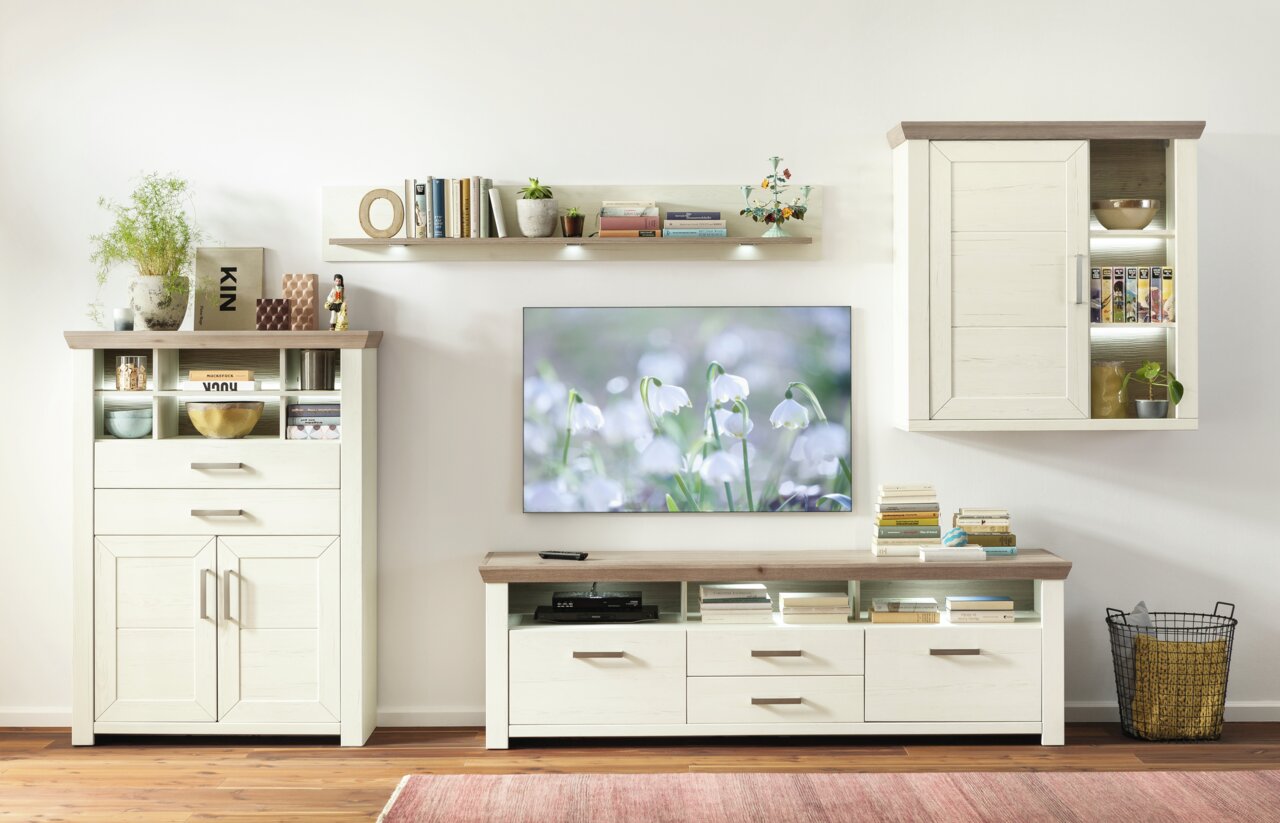 Wohnzimmer mit modernem Hängeelement in Holzoptik, frontal betrachtet, neben einem Fernseher und weiteren Möbelstücken.