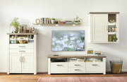 Wohnzimmer mit modernem Hängeelement in Holzoptik, frontal betrachtet, neben einem Fernseher und weiteren Möbelstücken.