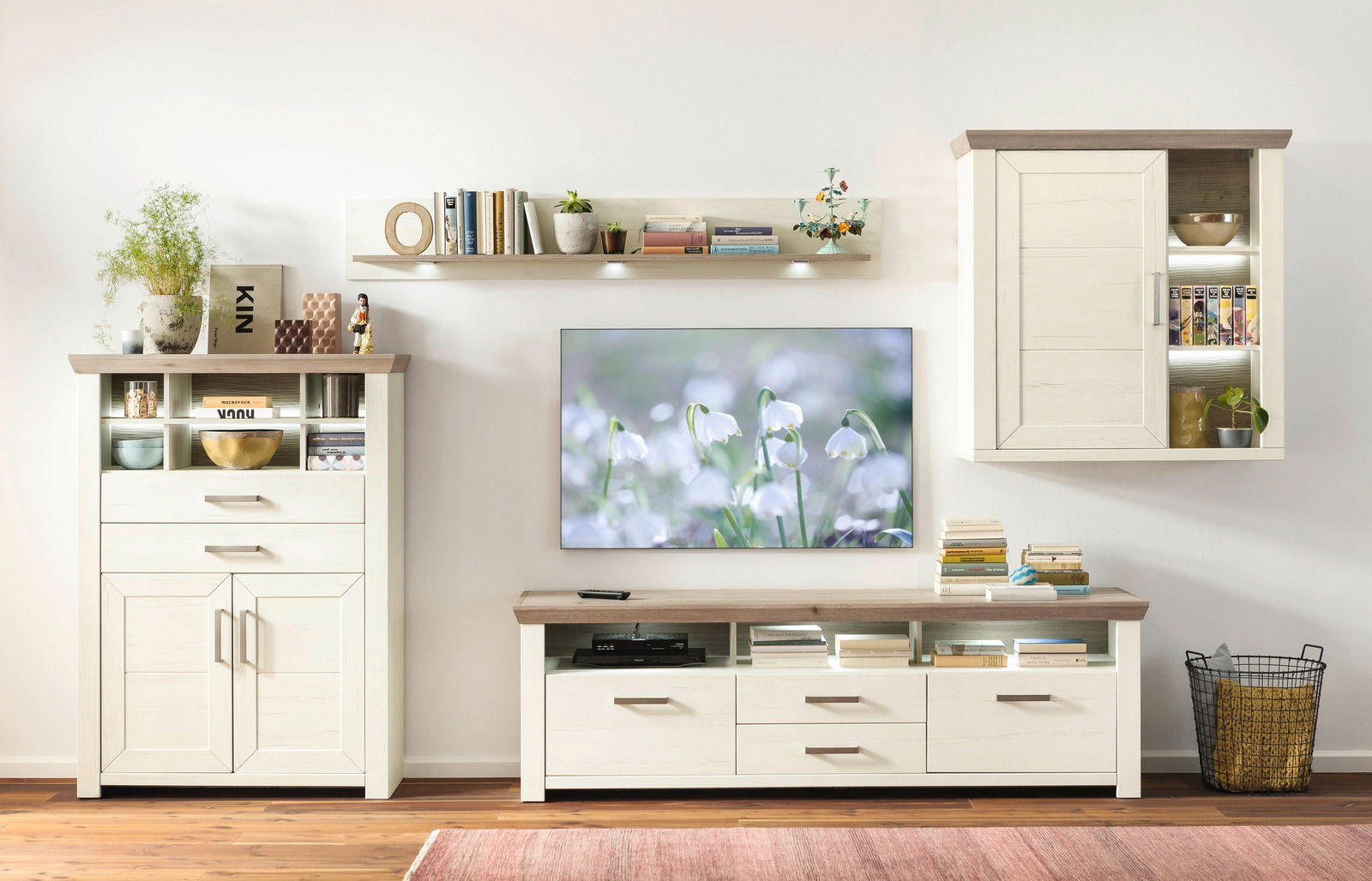 Wohnzimmer mit modernem Hängeelement in Holzoptik, frontal betrachtet, neben einem Fernseher und weiteren Möbelstücken.