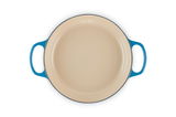 Runde, cremefarbene Auflaufform mit blauen Griffen, Ansicht von oben