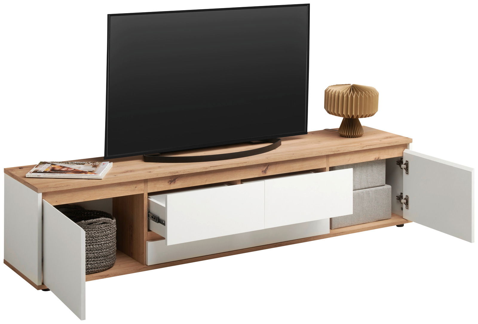 XL-TV-Lowboard aus Holz mit offenen Schubladen und Türen, von vorne betrachtet. Auf der Oberseite steht ein großer Fernseher, daneben eine Lampe und Zeitschriften.