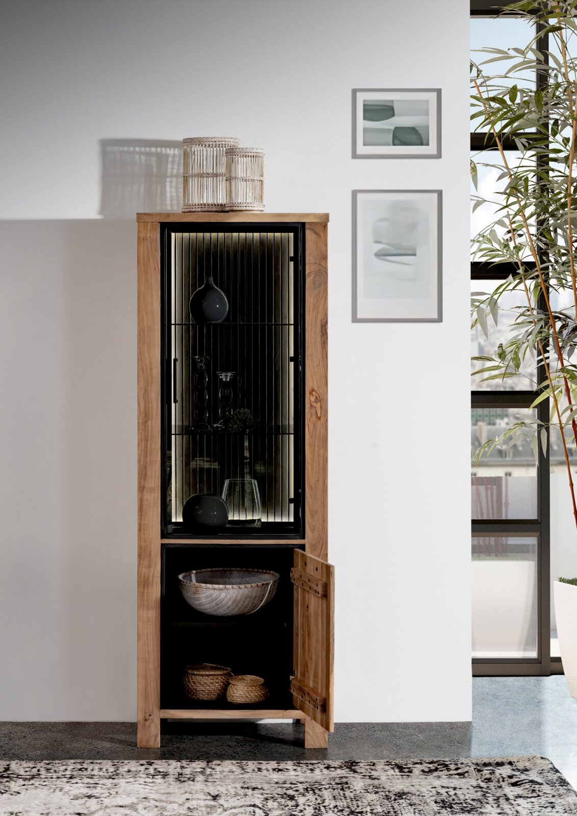 Houten vitrinekast met glazen deur, versierd met vazen en manden, gezien vanuit een vooraanzicht in een moderne woonkamer.