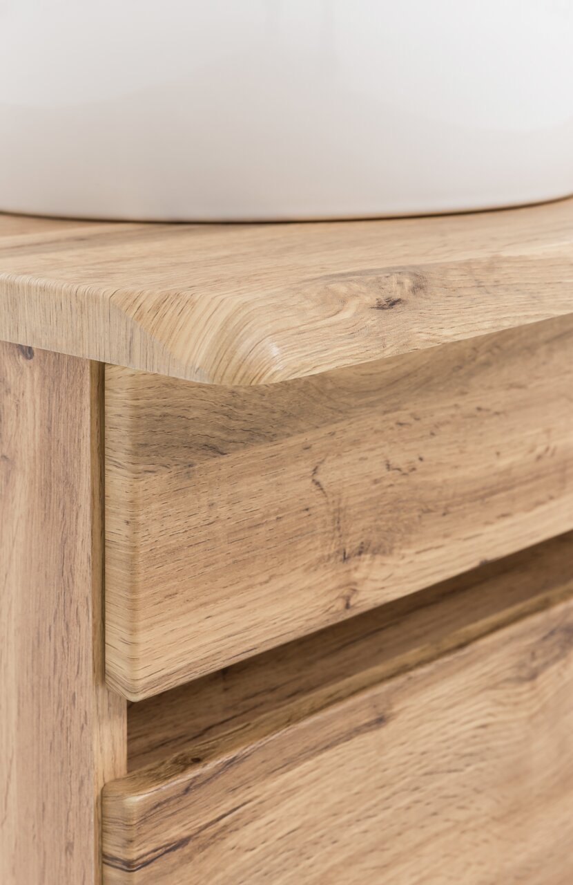Close-up van een houten wastafelmeubel met natuurlijke nerf, gezien vanaf de zijkant