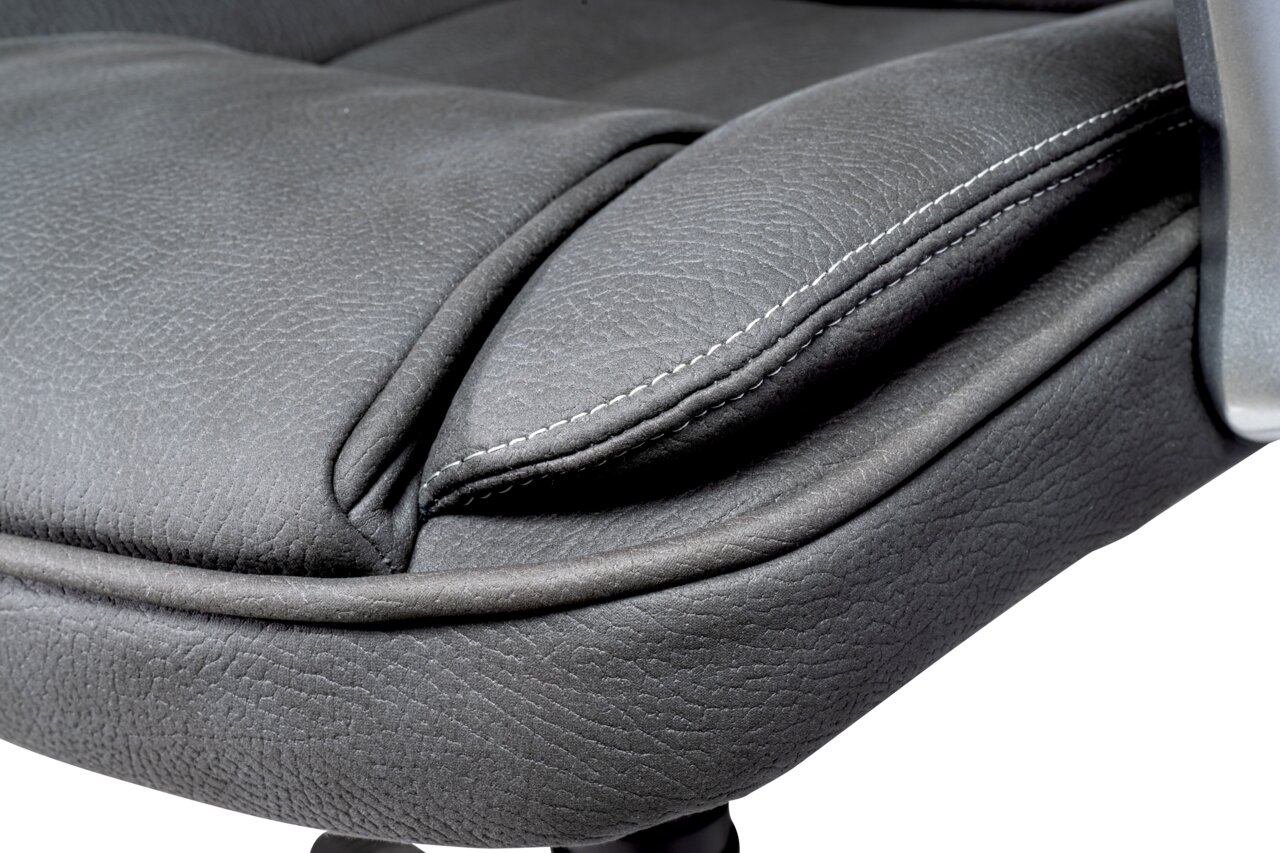 Nahaufnahme eines grauen Chefsesselsitzes mit sichtbaren Nähten und Textur, seitliche Perspektive