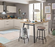 Moderne L-förmige Küche in Beige mit Holzarbeitsplatte und Kücheninsel/Esstisch, zwei Barhockern und Pendelleuchte, aufgenommen in leichter Schrägansicht von vorn im hellen Raum