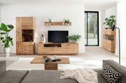 Wohnzimmeransicht mit der Linea Natura Wandkombination GEORGIA in hellem Holz, bestehend aus einem TV-Schrank, einem hohen Schrank und einem Wandregal, dekoriert mit Pflanzen und modernen Accessoires.