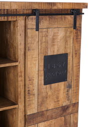 Nahaufnahme eines rustikalen Highboards aus Holz mit Schiebetür und schwarzem Metallschild mit der Aufschrift '1867 Factory'.