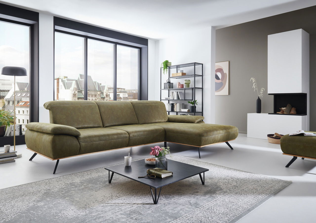 Moderne Longchairkombination in einem stilvollen Wohnzimmer mit großen Fenstern, die einen Blick auf die Stadt bieten. Perspektive von vorne links.