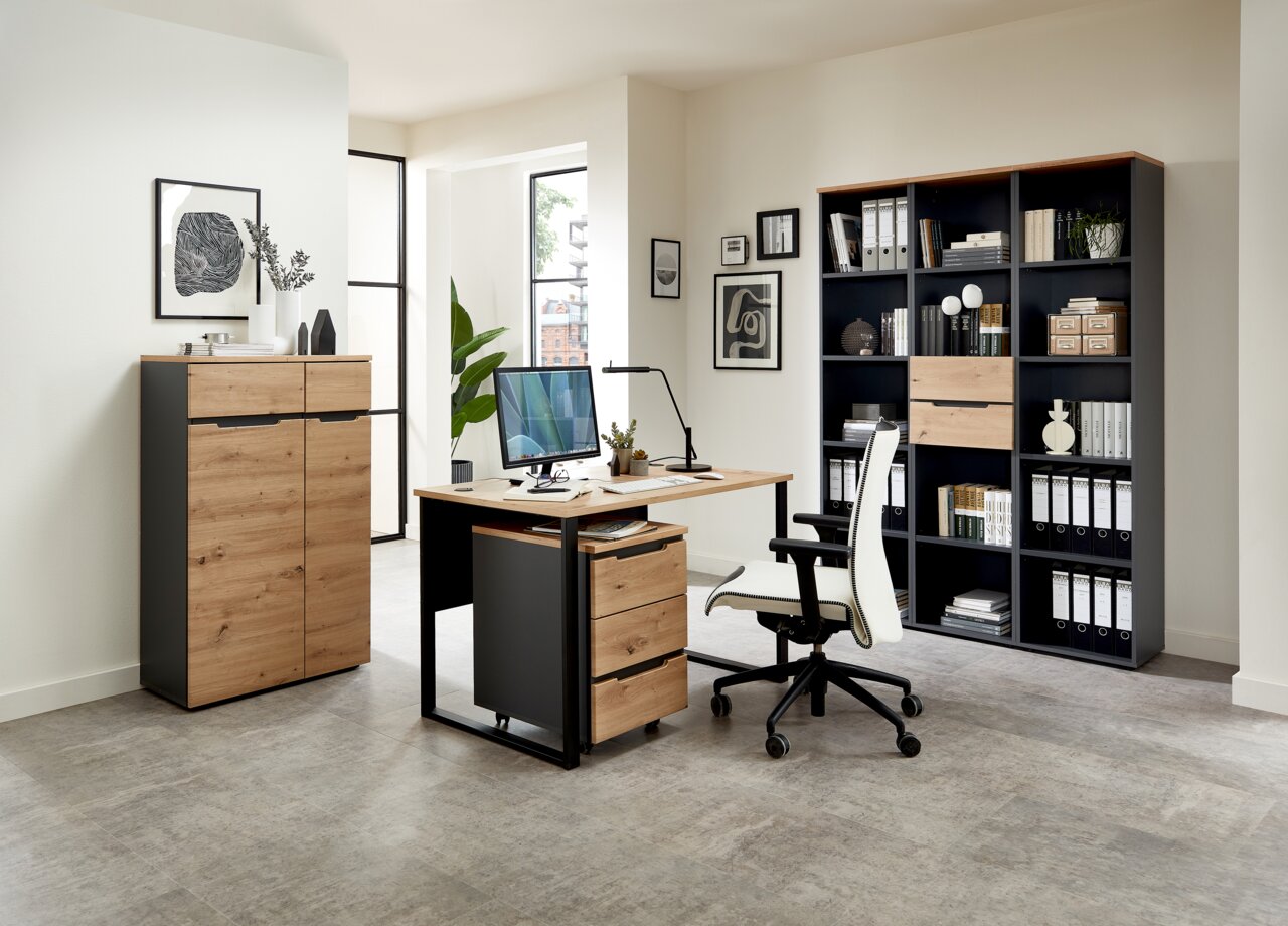 Voleo Regal schmal DETROIT Moderne Büromöbel in einem hellen Raum, bestehend aus einem Schreibtisch mit Rollcontainer, einem Aktenschrank und einem Regalschrank, aus Holz und Metall, seitliche Perspektive.