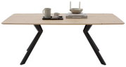 Moderne houten eettafel met een zwart metalen onderstel, gezien vanaf de voorkant, versierd met serviesgoed en boeken.