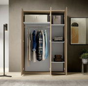 Drehtürenschrank 3-türig in moderner Innenansicht mit geöffneter Perspektive, zeigt hängende Kleidung und Regalfächer.