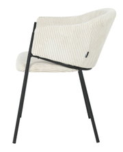 Zijaanzicht van een moderne fauteuil met crèmekleurige, geribbelde stoffen bekleding en zwarte metalen poten.