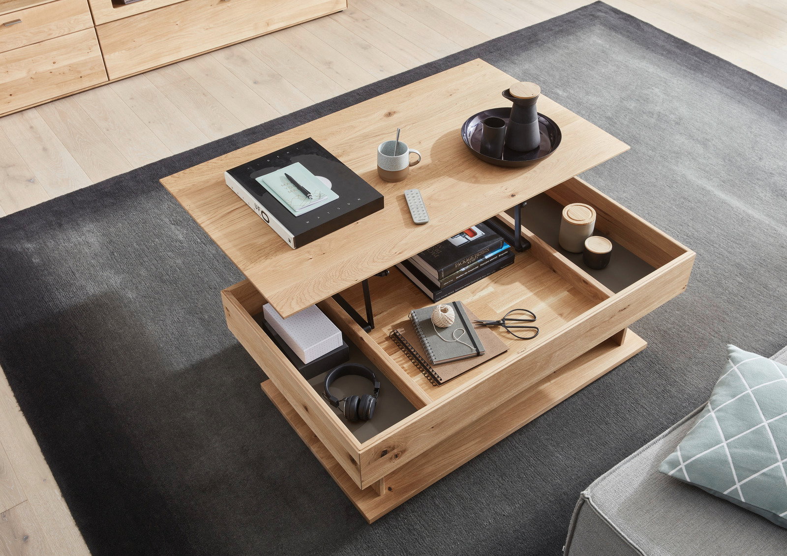 Moderner Couchtisch aus Holz mit Schubladen, von oben fotografiert, dekoriert mit Büchern, Tasse und Tablett.