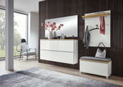 Moderne Garderobeneinrichtung mit weißem Hängeschuhschrank, Spiegel und Garderobenbank in einem stilvollen Raum mit Holzverkleidung, seitliche Perspektive.