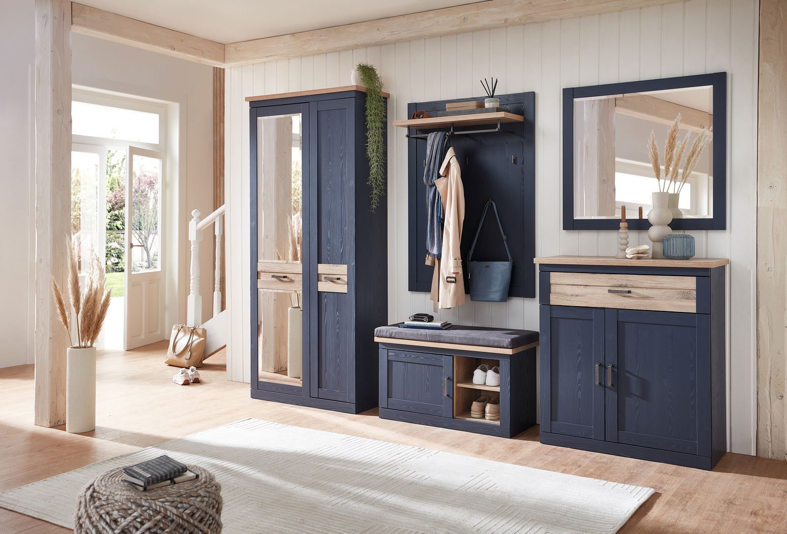 Moderne Garderobeneinrichtung in Holzoptik mit dunkelblauen Schränken, Spiegel und Sitzbank, seitliche Perspektive.