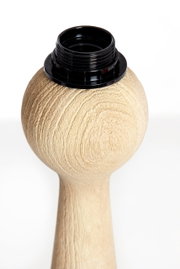 Nahaufnahme eines Lampenfußes aus Holz mit schwarzer Fassung, seitliche Perspektive.