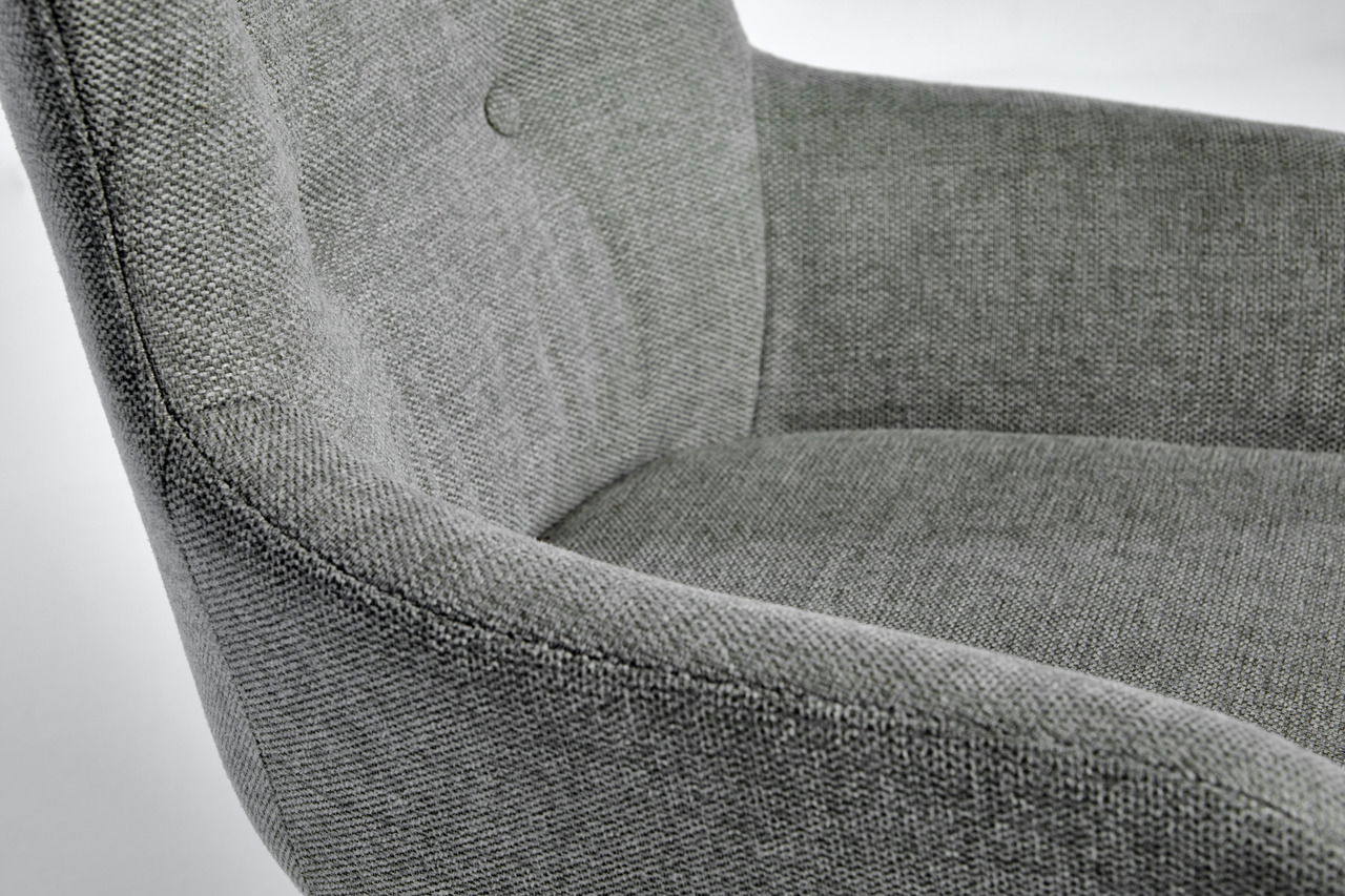 Nahaufnahme eines grauen Stuhls mit gepolsterter Rückenlehne und Armlehnen, seitliche Perspektive