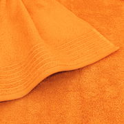 Nahaufnahme eines orangefarbenen Handtuchs mit dekorativen Streifen, von oben betrachtet.