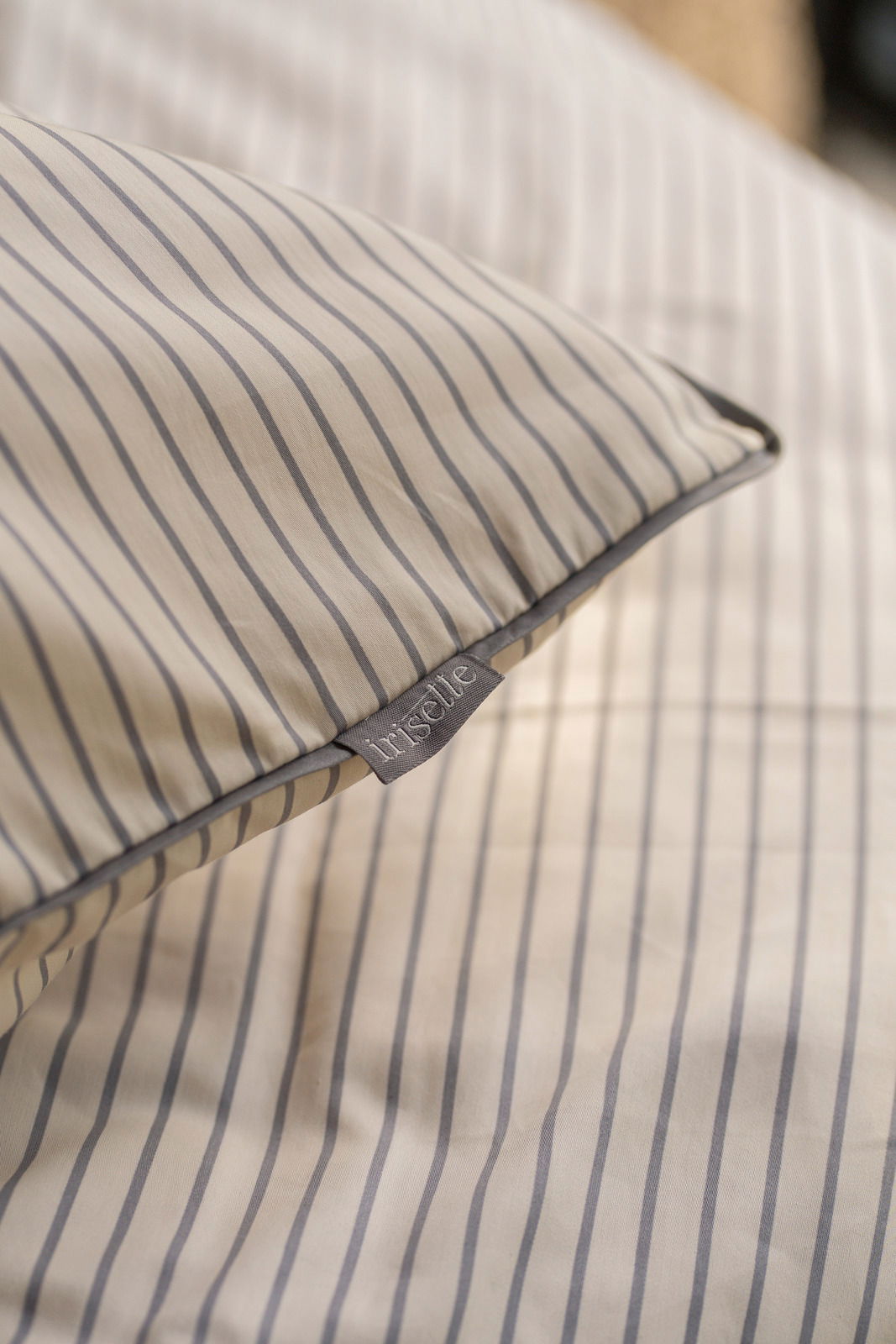 Nahaufnahme einer gestreiften Bettwäsche mit Etikett, das den Markennamen zeigt.
