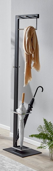 Schwarzer freistehender Garderobenständer aus Metall mit Haken, Kleiderstange und integriertem Schirmständer, mit Schal und zwei Regenschirmen, fotografiert in leichter Seitenansicht vor hellgrauer Wand.