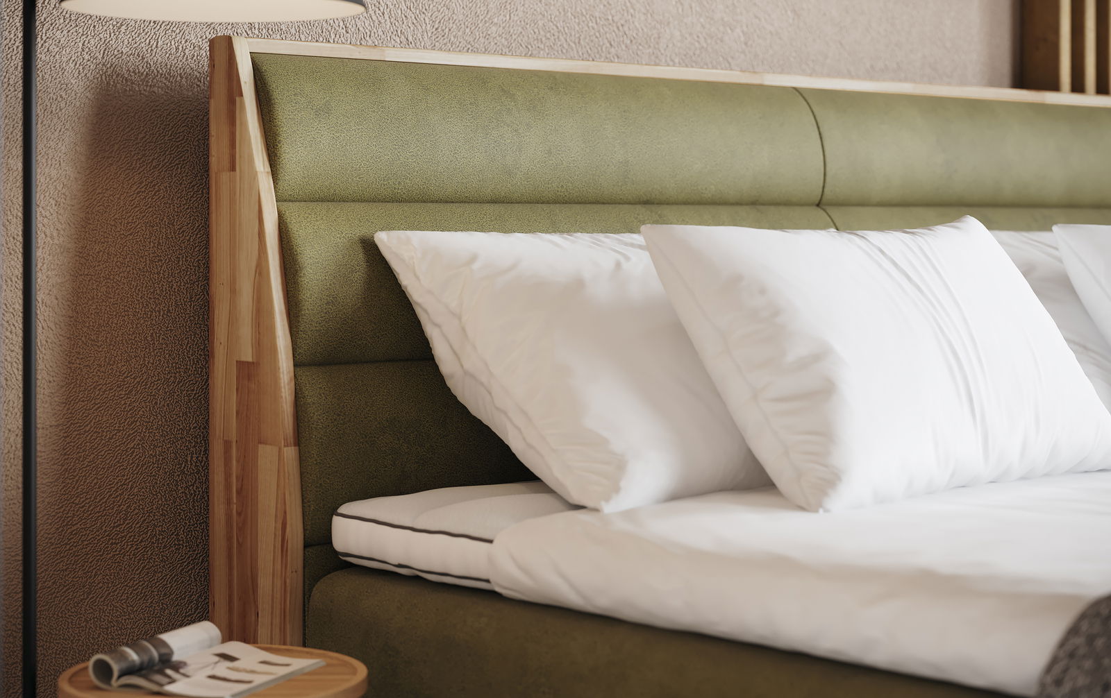 Nahaufnahme eines Boxspringbetts mit grünem Kopfteil und weißen Kissen, seitliche Perspektive