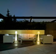 Stehleuchte LOLA 110 in einem modernen Außenbereich, umgeben von weißen Rattanmöbeln, bei Dämmerung beleuchtet.