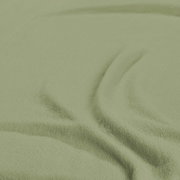 Nahaufnahme eines grünen Spannbetttuchs mit weicher Textur, von oben betrachtet.