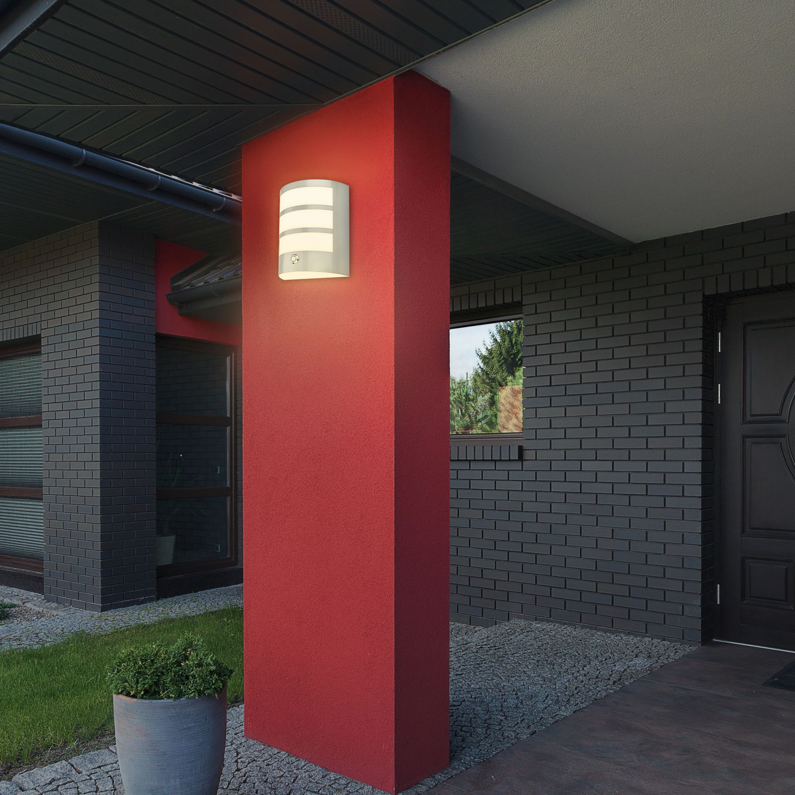 Briloner Akku-Außenwandleuchte Moderne Akku-Außenwandleuchte an einer roten Wand, seitliche Perspektive