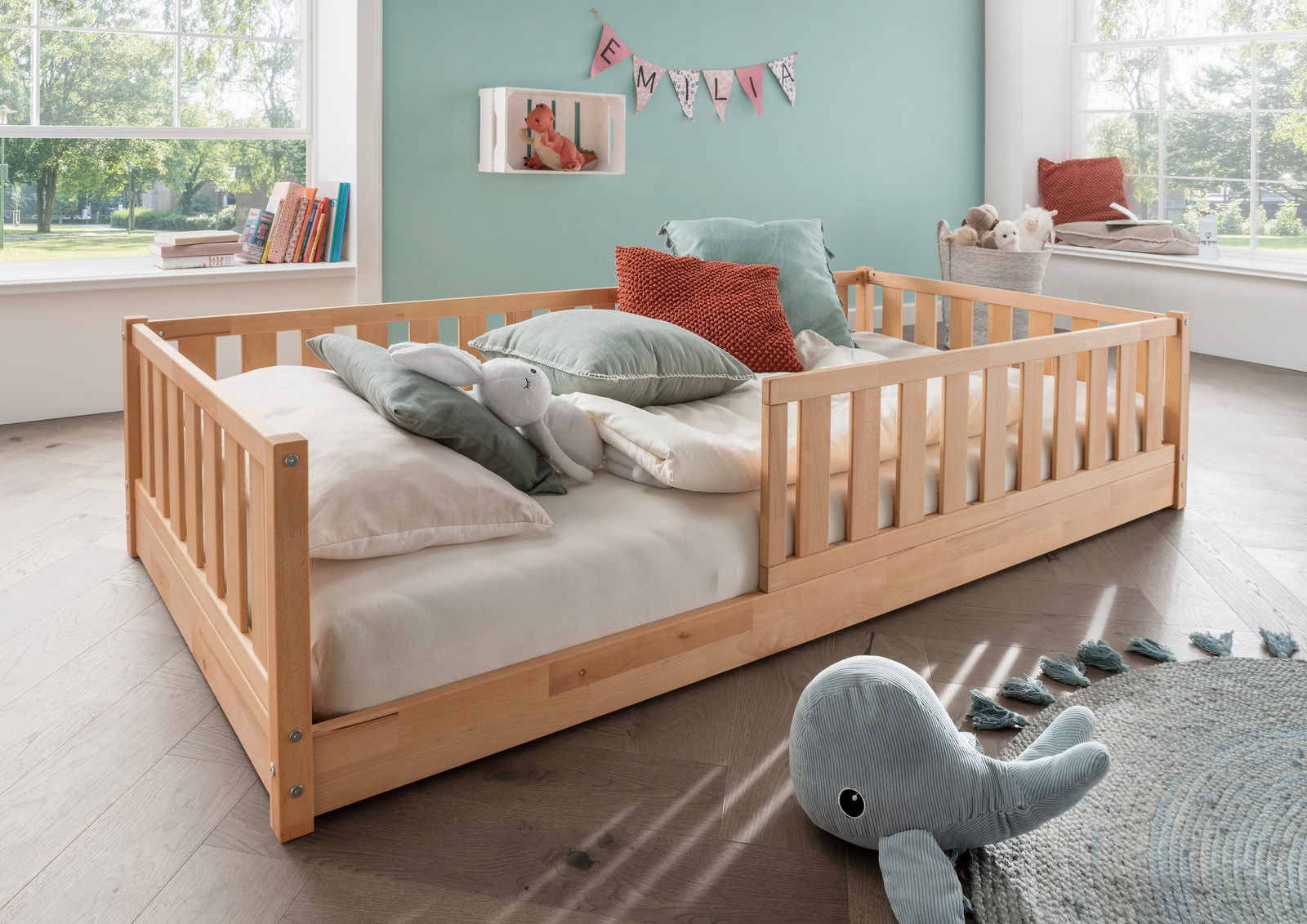 Holzbodenbett für Kinder mit Kissen und Kuscheltieren, seitliche Perspektive