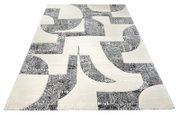 Moderner Teppich in Creme und Grau mit abstraktem geometrischem Muster, schräg von oben in Perspektive fotografiert